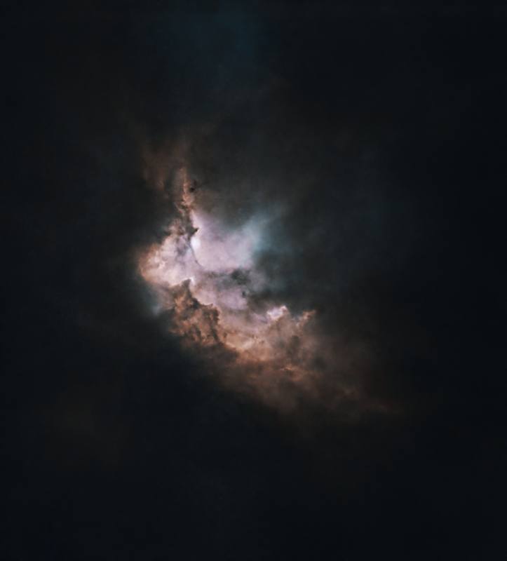 Starless version of the Wizard Nebula NGC 7380, showing only the glowing pink, white and rust-brown gas and dark dust lanes on a black background